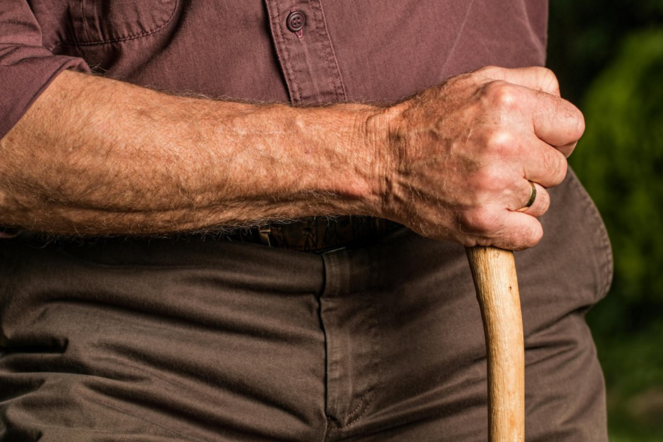 an elderly man holding a stick