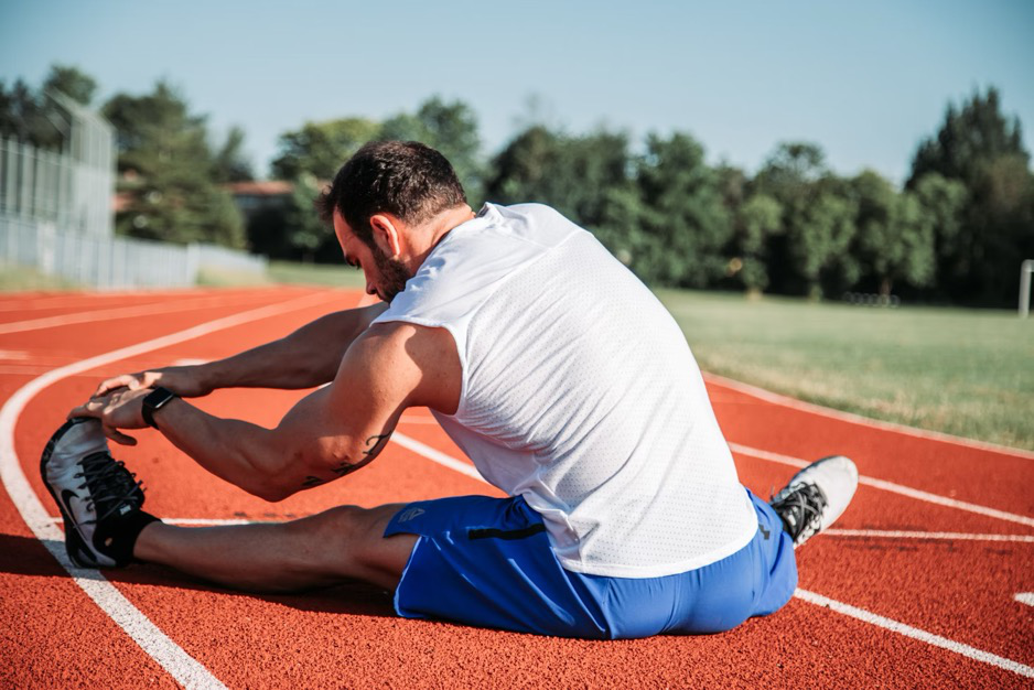 a man stretching on a running track