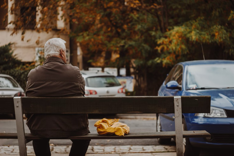 an elderly man sitting on a bench