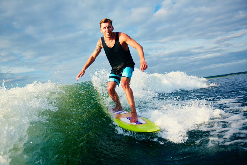 An athlete wakeboards under the summer sun.