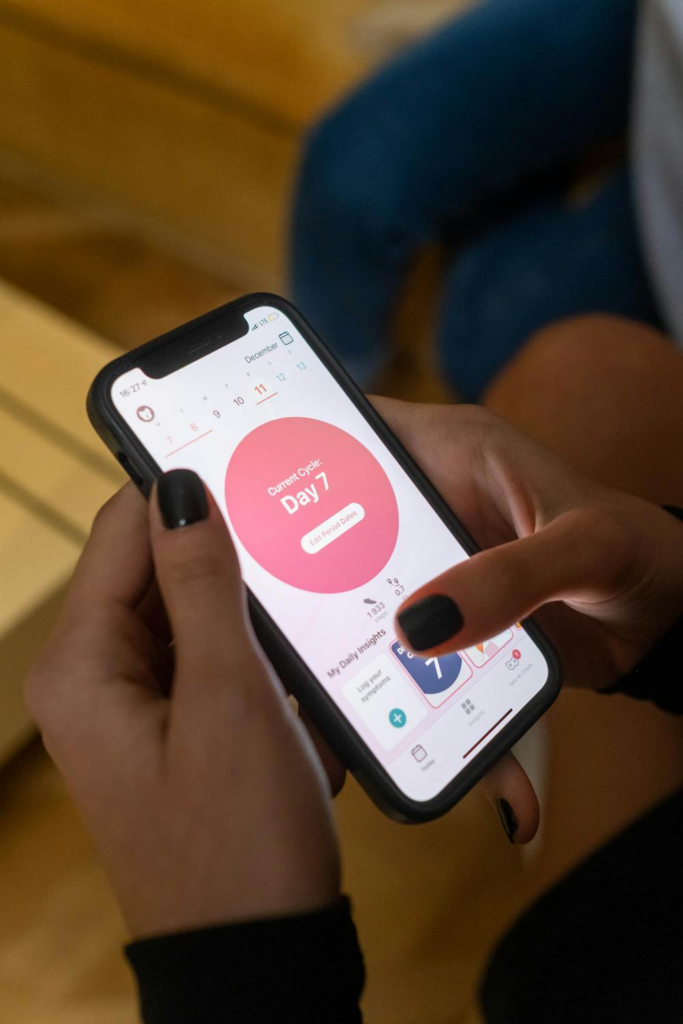 A woman checking her menstrual cycle using an app on her smartphone.