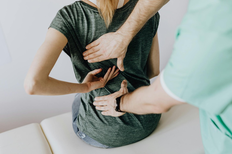 A spine specialist examining a patient’s back.