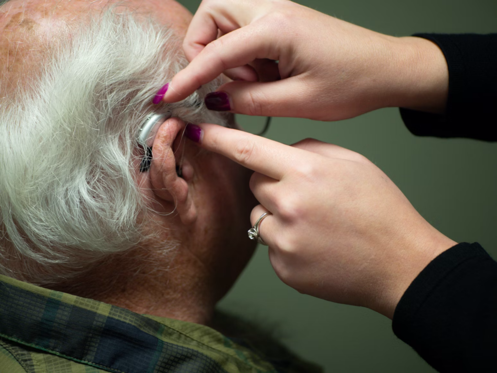 An audiologist performing a hearing checkup on a patient.