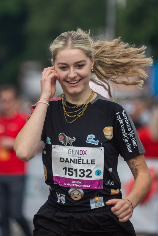 A woman smiles while running a marathon.