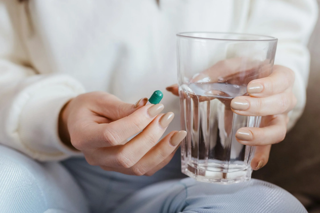 A woman taking medication for menstrual pain relief.