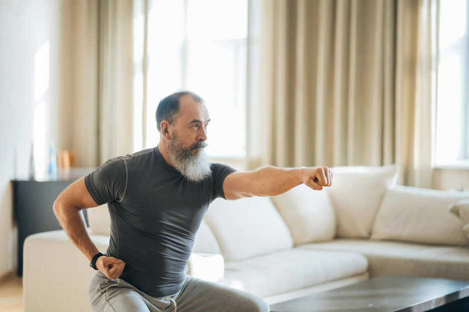 A man doing a punching exercise in his living room, focusing on mobility and joint health.